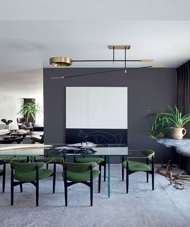 El color gris en pintura antracita en la cocina abierta o alicatado en el comedor, resalta el mobiliario, las sillas verdes y la mesa de vidrio.