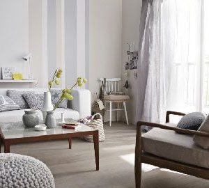 Blanco, un color de salón no sombrío y decididamente chic.  Con una tonalidad clara de pintura gris y un suelo de color topo claro, la sala de estar adquiere color.