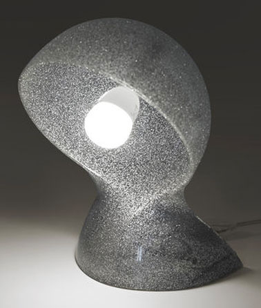 Esta lámpara de mesa de diseño para el dormitorio es una edición limitada de la marca Artemide.  Pedrería y lentejuelas para hacer de tu hogar un interior estrella.  Material: termoplástico moldeado