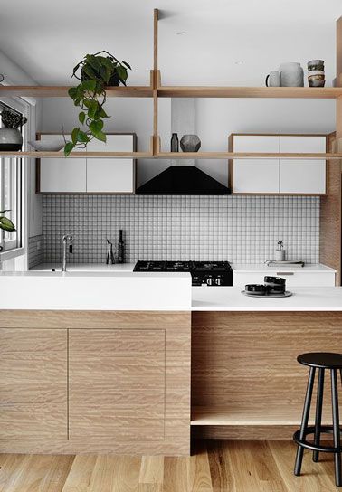 El salpicadero de azulejos adhesivos formado por pequeños cuadrados blancos combina a la perfección con la decoración de esta cocina de madera y blanco ultra acogedor
