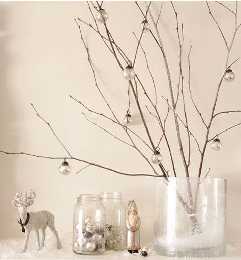 Una decoración navideña fácil de hacer con unas pequeñas ramas de árbol y bolas transparentes para decorar la chimenea.