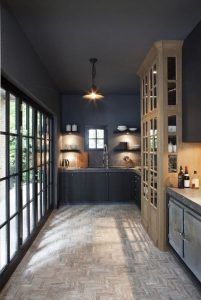 Esta cocina de cuerpo entero utiliza gris carbón como pintura en la pared y el techo.  Una cocina moderna y auténtica en gris con muebles de madera.