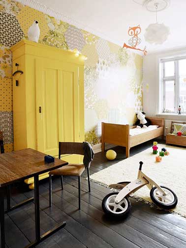 Repintado en pintura amarilla, el armario de la habitación infantil aporta una nota divertida a la decoración.  Combinado con papel tapiz de patrón coordinado