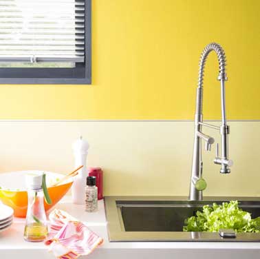 Una pintura amarilla aporta toda su energía al salpicadero de esta cocina moderna.  Pintado con dos colores a juego.  Pintura satinada de sorbete de limón, Dulux
