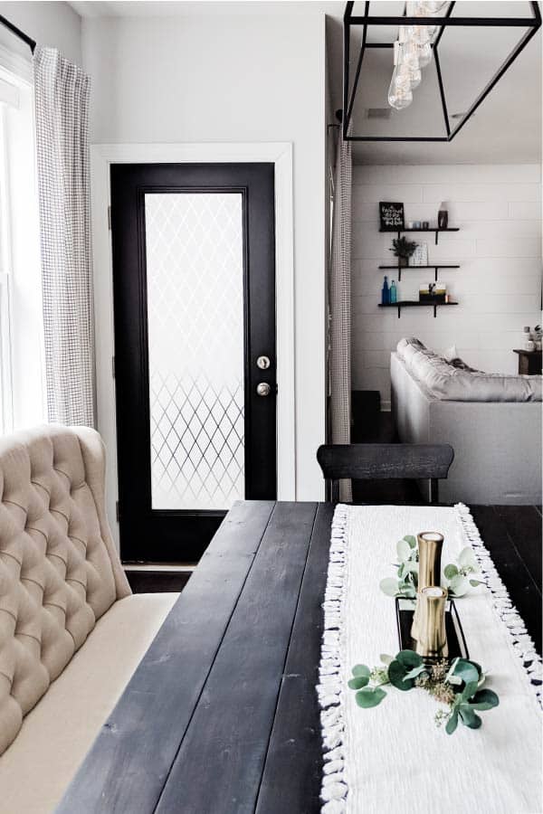puerta pintada de negro con ventana de película en el estilo de una casa de campo comedor