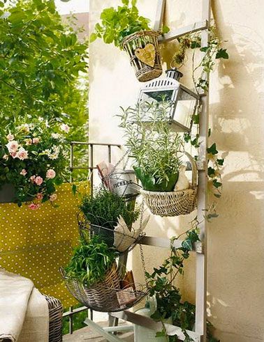 montar un jardín de flores y plantas en un pequeño balcón con una jardinera en una barandilla y una escalera de madera para colgar macetas y jardineras en la pared 