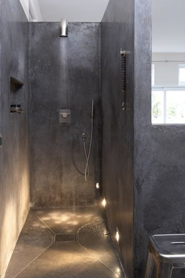 Una ducha italiana en un baño de hormigón encerado