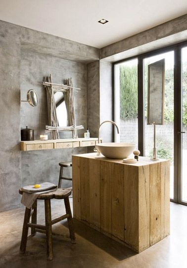 Un cuarto de baño rústico con suelo de hormigón encerado, tocador de madera y grifería de latón