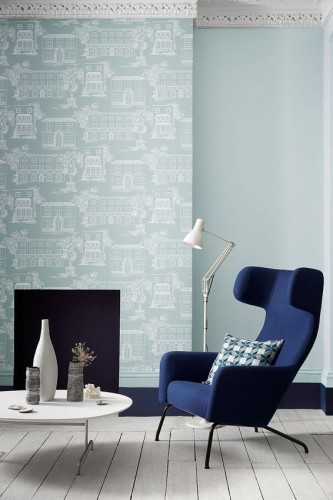 El salón refleja una decoración refinada con pintura azul disponible en tres tonos sobre una pared con papel pintado a juego. Pintura Hampstead, Dock Blue 252 y Penumbra con Celestial Blue 101 de Little Greene.
